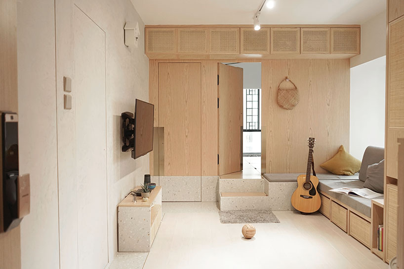 absence from island completes apartment interior in hong kong with rattan, wood + terrazzo