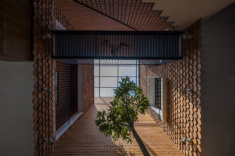 red brick and fish-scale tiles clad this family house by CTA in vietnam designboom