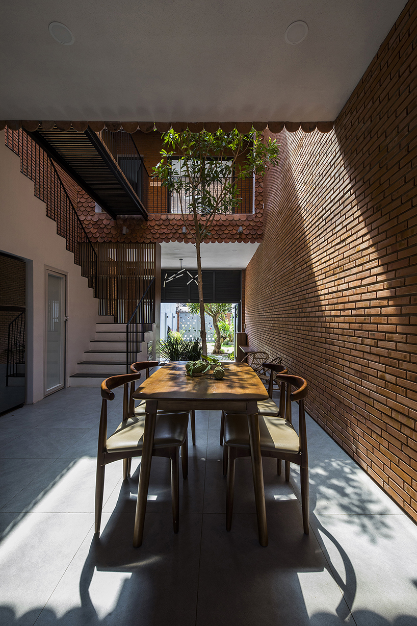 red brick and fish-scale tiles clad this family house by CTA in vietnam designboom