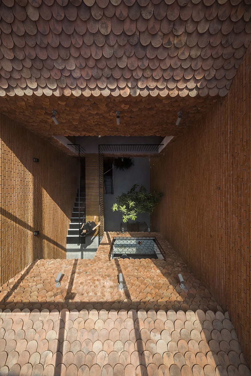 red brick and fish-scale tiles clad this family house by CTA in vietnam designboom