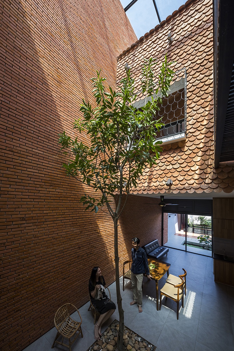 red brick and fish-scale tiles clad this family house by CTA in vietnam designboom