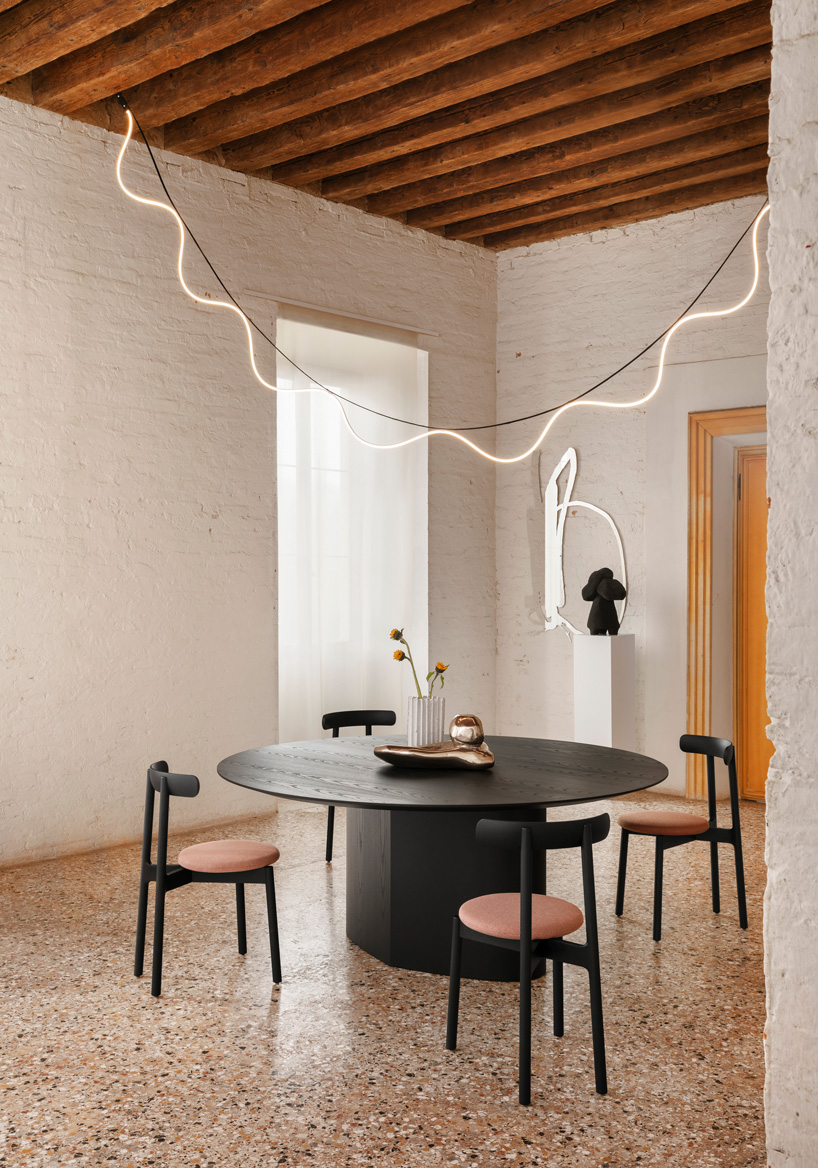 curving tabletops perch atop a monolithic, leaf-shaped base for miniforms' monoplauto table