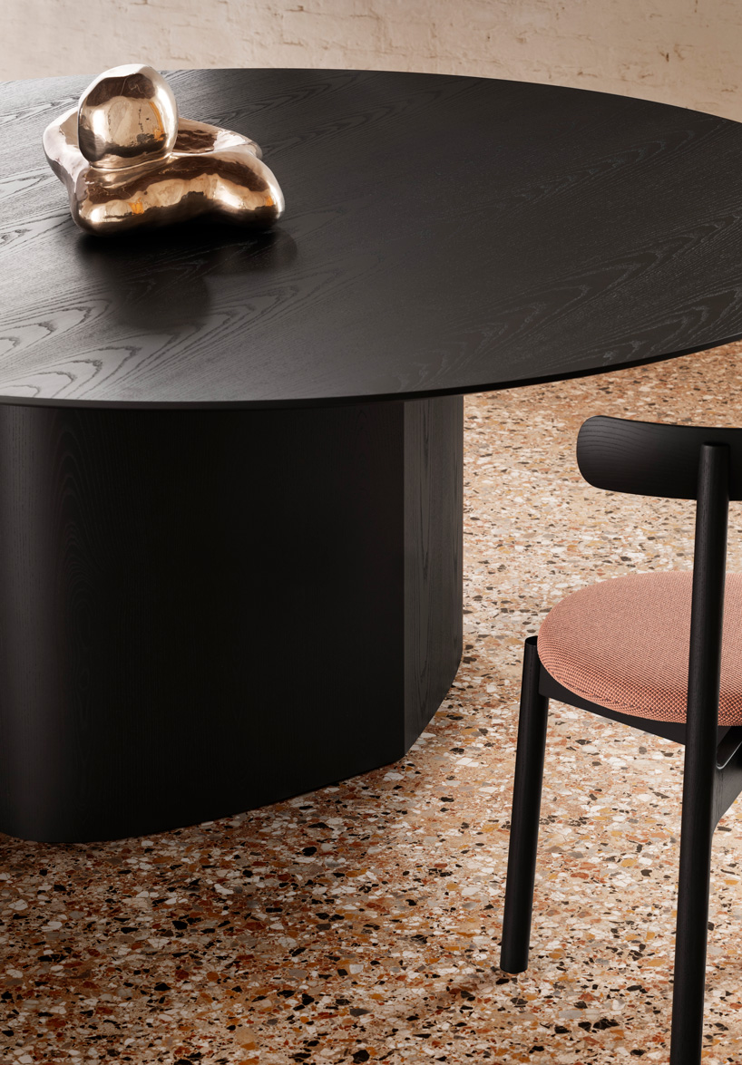 curving tabletops perch atop a monolithic, leaf-shaped base for miniforms' monoplauto table