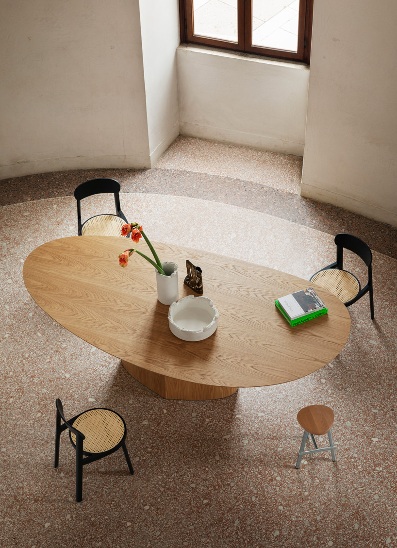 curving tabletops perch atop a monolithic, leaf-shaped base for miniforms' monoplauto table