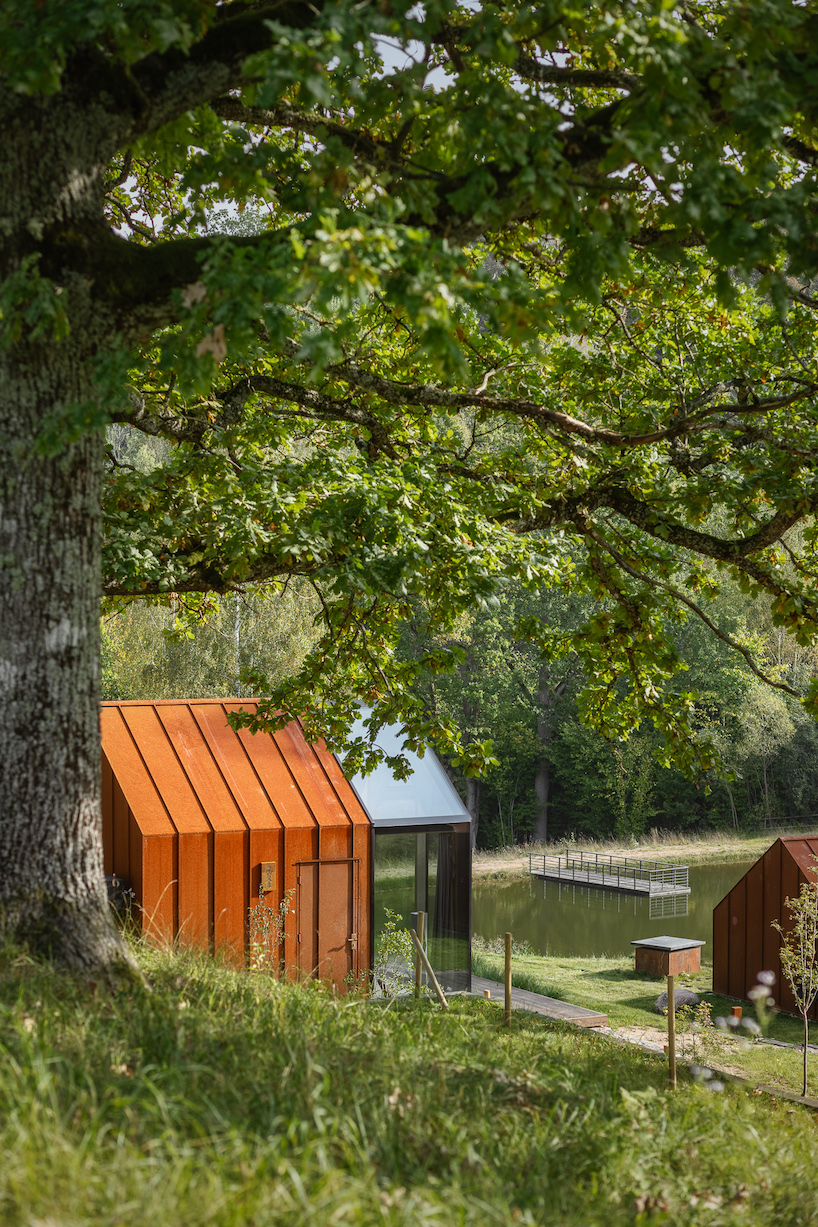 open AD designs three corten steel and glass cabins in rural latvia designboom