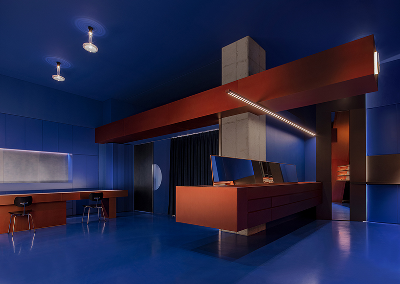 bold red stainless steel fixtures adorn blue eyewear store interior by WGNB in seoul