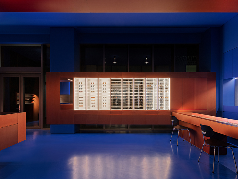 bold red stainless steel fixtures adorn blue eyewear store interior by WGNB in seoul