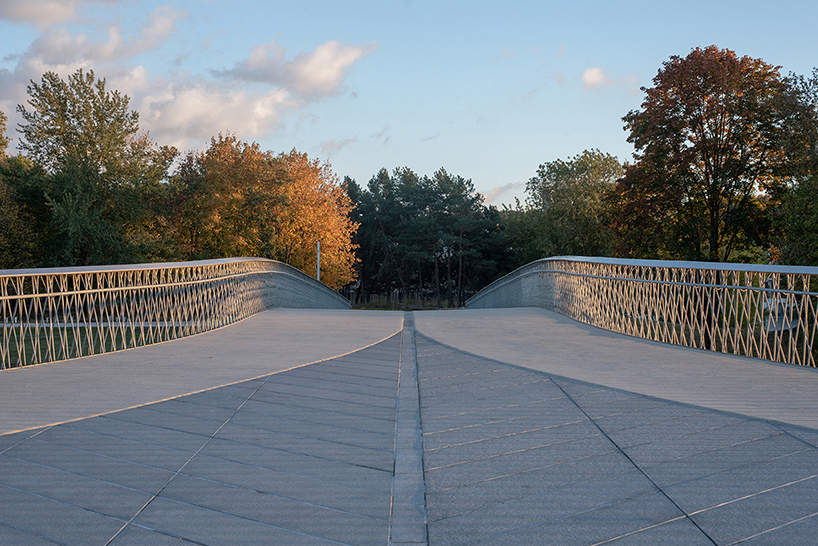 winding pedestrian bridge-plaza converges historic lithuanian city center with public park