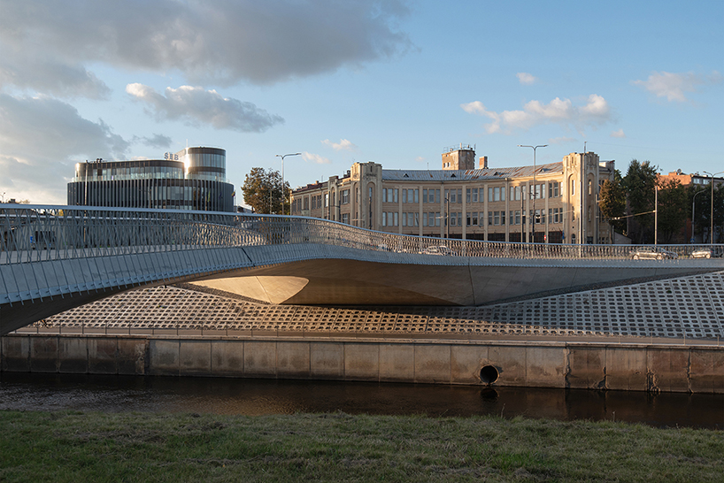winding pedestrian bridge-plaza converges historic lithuanian city center with public park