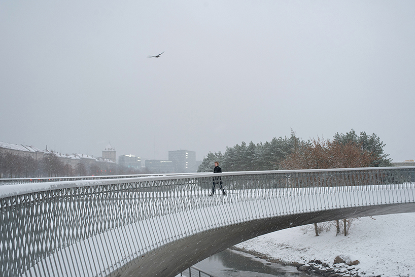 winding pedestrian bridge-plaza converges historic lithuanian city center with public park