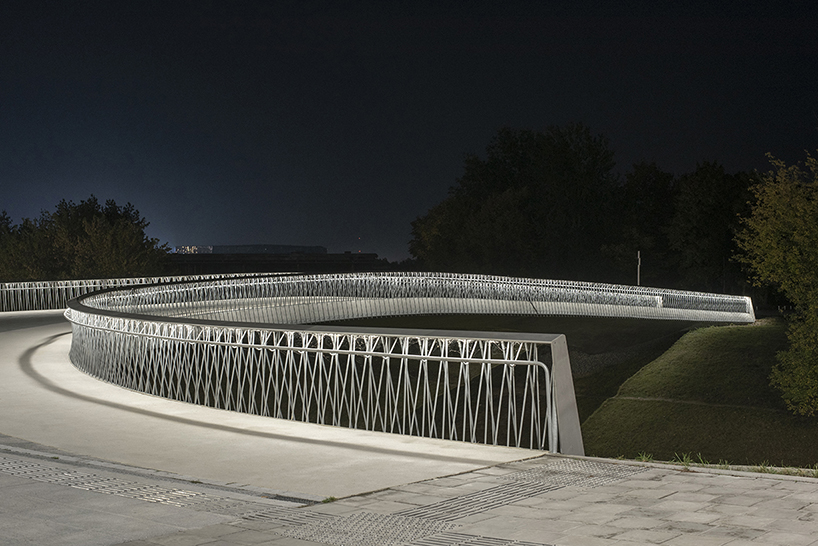 winding pedestrian bridge-plaza converges historic lithuanian city center with public park