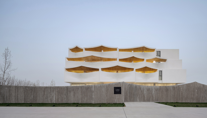 curved white wall façade adorns new hotel model in industrial site of china