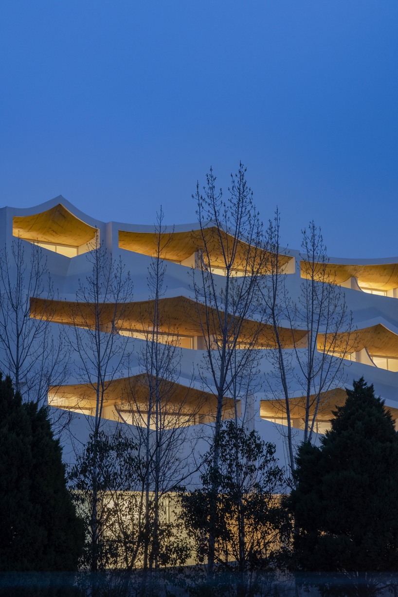 curved white wall façade adorns new hotel model in industrial site of china - 7