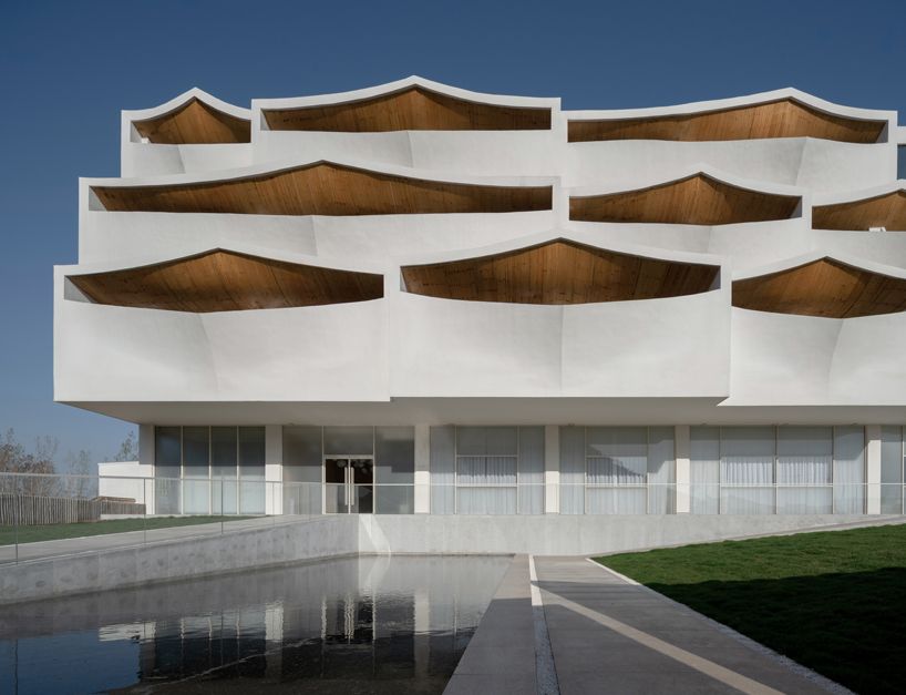 curved white wall façade adorns new hotel model in industrial site of china
