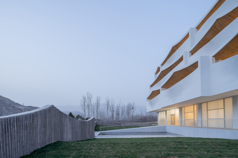 curved white wall façade adorns new hotel model in industrial site of china