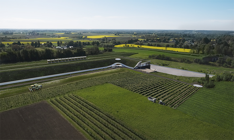 unism studio blends subterranean factory's green roof into poland's rural landscape