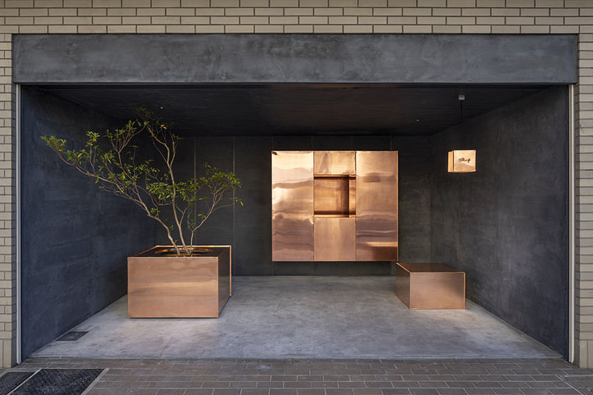 reflective floating copper cubes clad arbol design's pitch-black store in japan