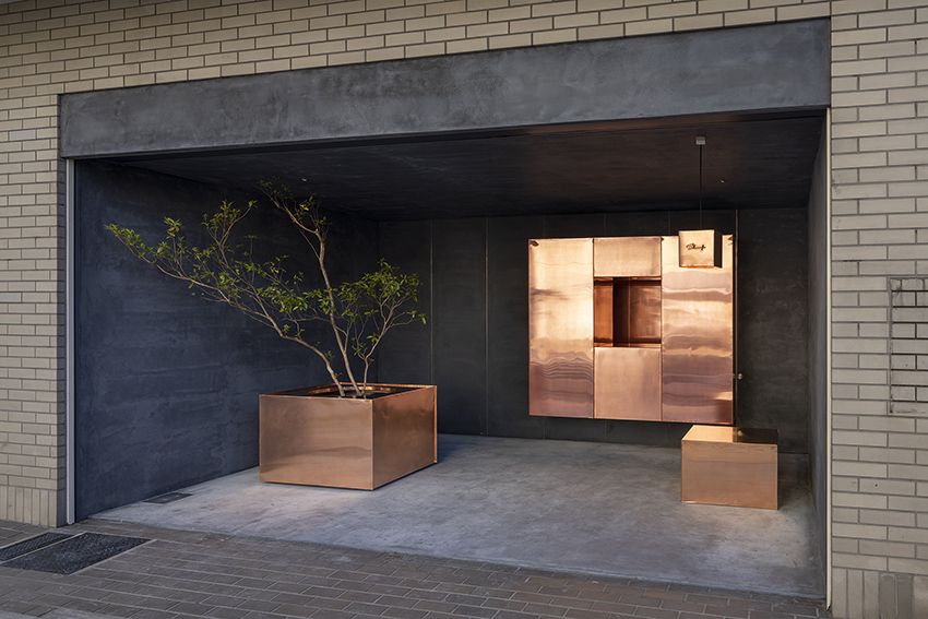reflective floating copper cubes clad arbol design's pitch-black store in japan