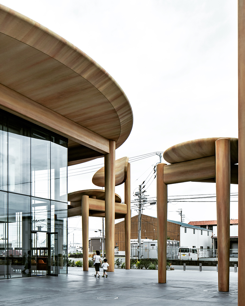 giant set of chairs and table shelters nikken sekkei's mixed-use 'sweets bank' in japan