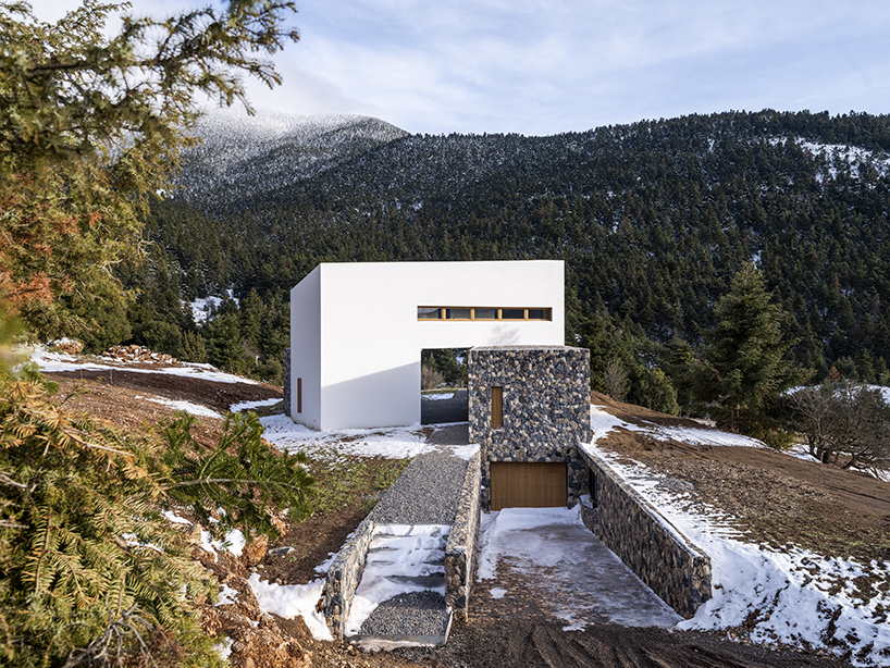 icy white volume overlays stone-built 'snowfall house' in greece