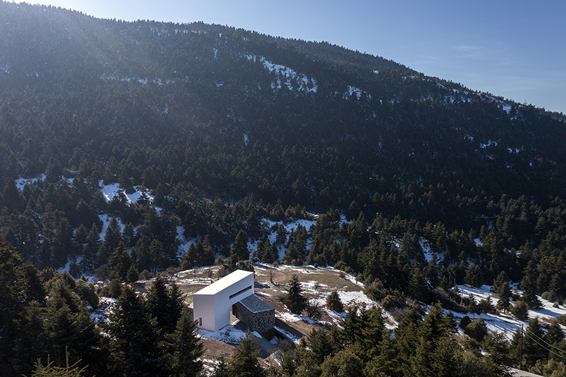 icy white volume overlays stone-built 'snowfall house' in greece