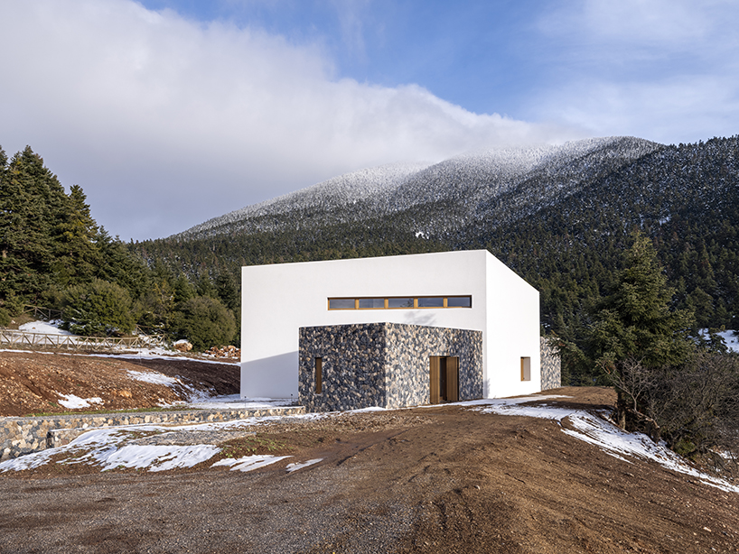 icy white volume overlays stone-built 'snowfall house' in greece