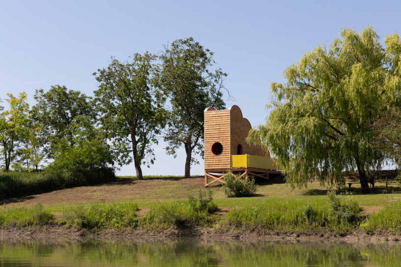 wrapped in wooden shingles, kollektiv plus x's cloud-shaped cyclist shelter ascends to views over iron curtain
