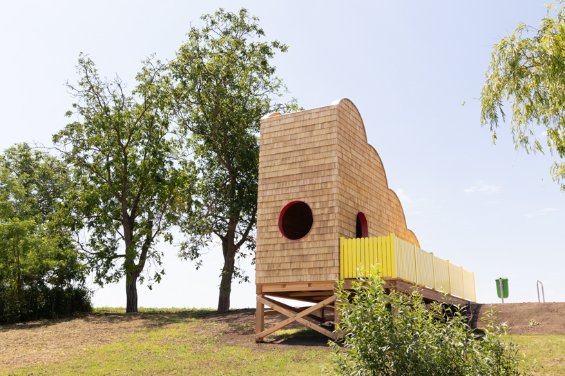 wrapped in wooden shingles, kollektiv plus x's cloud-shaped cyclist shelter ascends to views over iron curtain