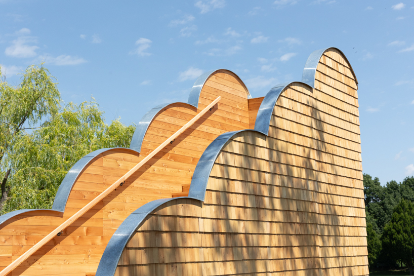 wrapped in wooden shingles, kollektiv plus x's cloud-shaped cyclist shelter ascends to views over iron curtain