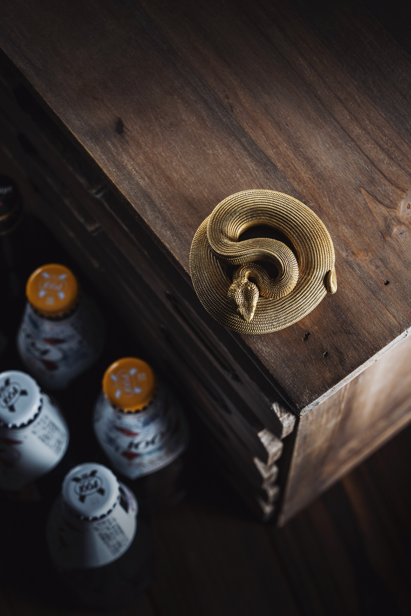 coppertist.wu hand engraves over 14,000 scales on this elegant viper bottle opener
