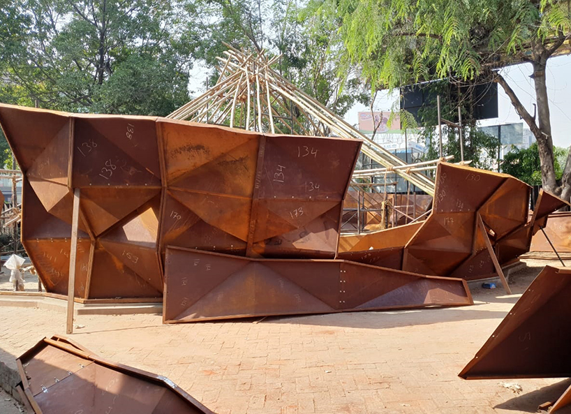 parametric metal tent with ridge paneled facade serves as multipurpose events space by andblack studio in india