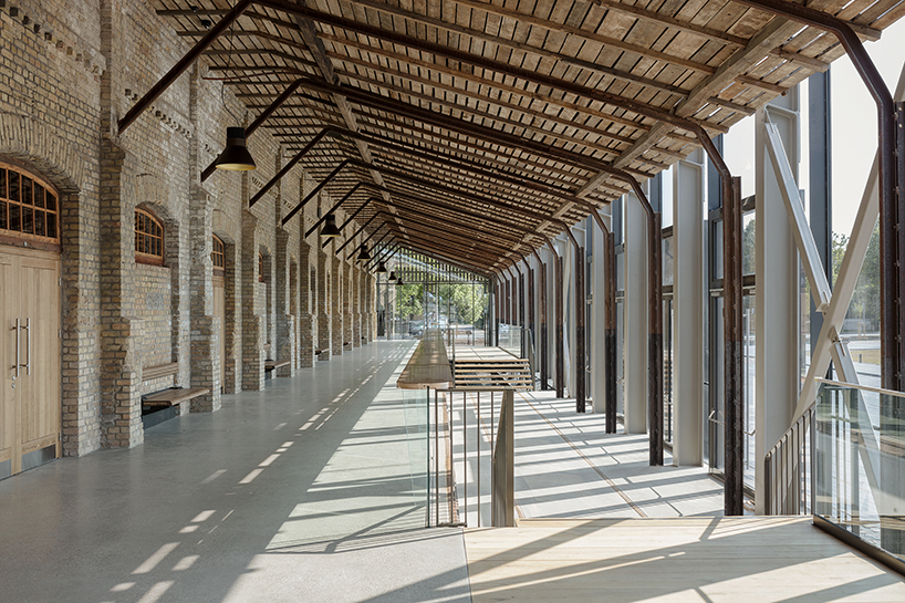 historic latvian cargo warehouse by sudraba arhitektura revived as cultural center, encased in glass and steel shell