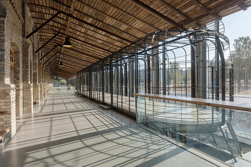 historic latvian cargo warehouse by sudraba arhitektura revived as cultural center, encased in glass and steel shell