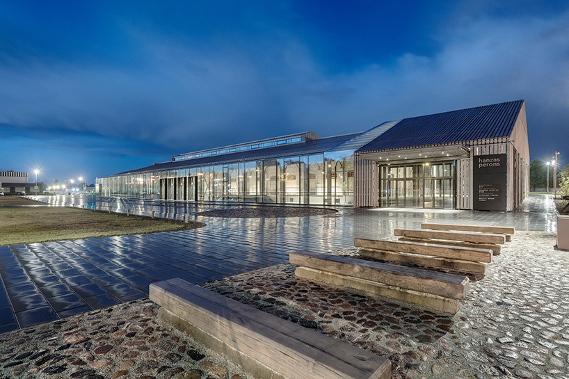 historic latvian cargo warehouse by sudraba arhitektura revived as cultural center, encased in glass and steel shell