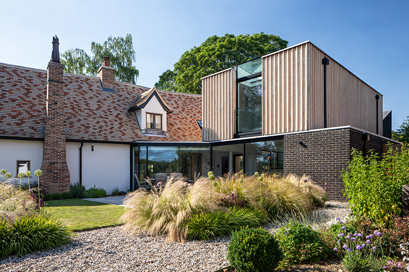 vertical oak cladded formation expands 17th-century renovated cottage in the UK