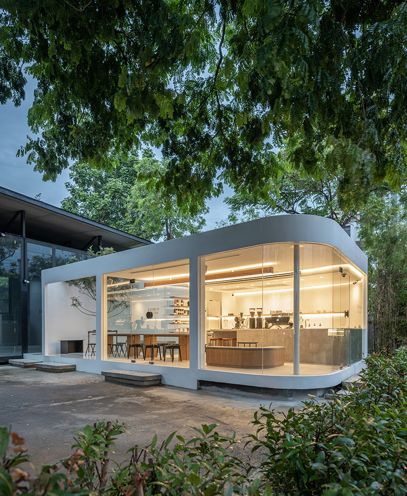 spacy architecture wraps serene bangkok cafe in floating glass