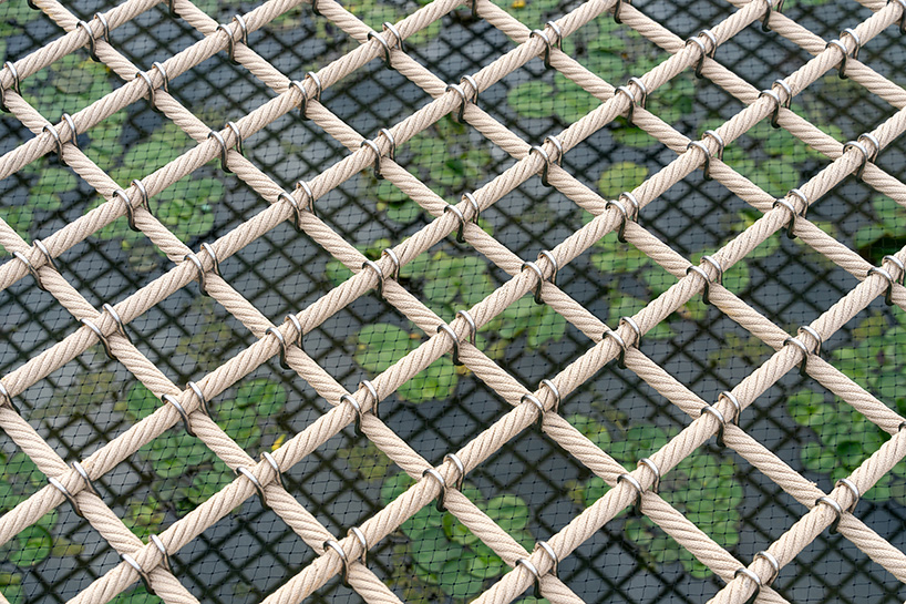 zxd architects stretches large woven net across pond in rural china, inviting rest and play