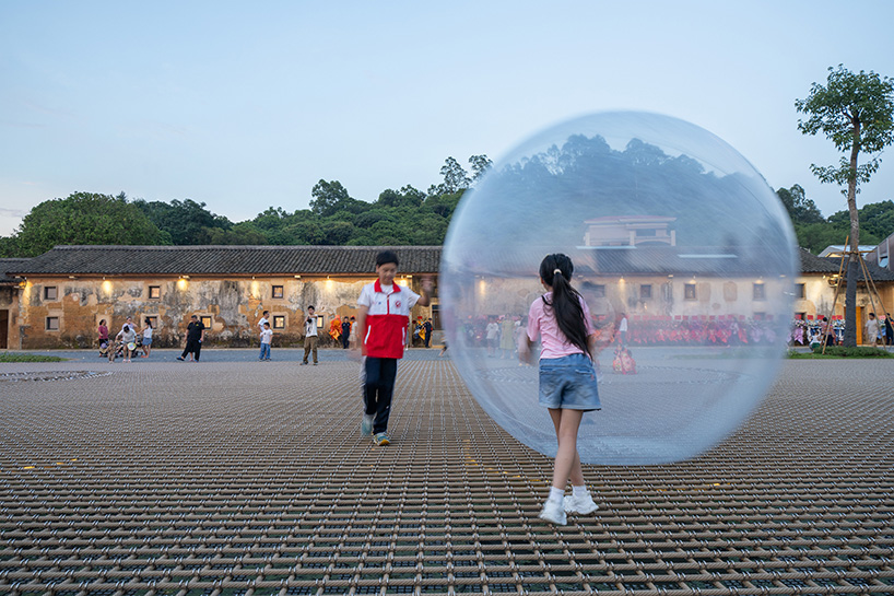 zxd architects stretches large woven net across pond in rural china, inviting rest and play