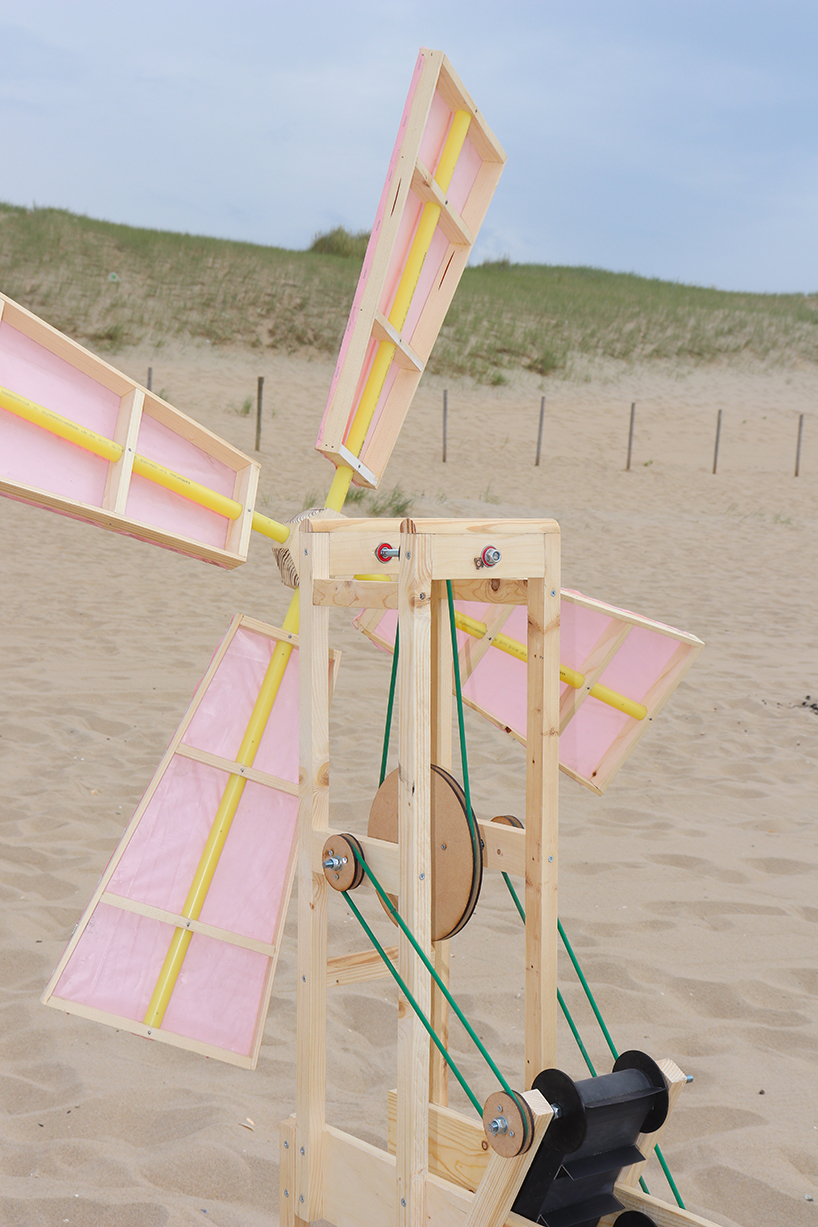 taiyi yu’s windmill on the beach rotates in the breeze to create an imprint in the sand