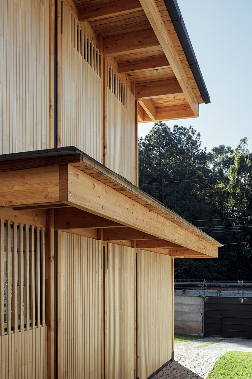 two identical wooden blocks form a mirroring c-shape residence in ecuador - 5