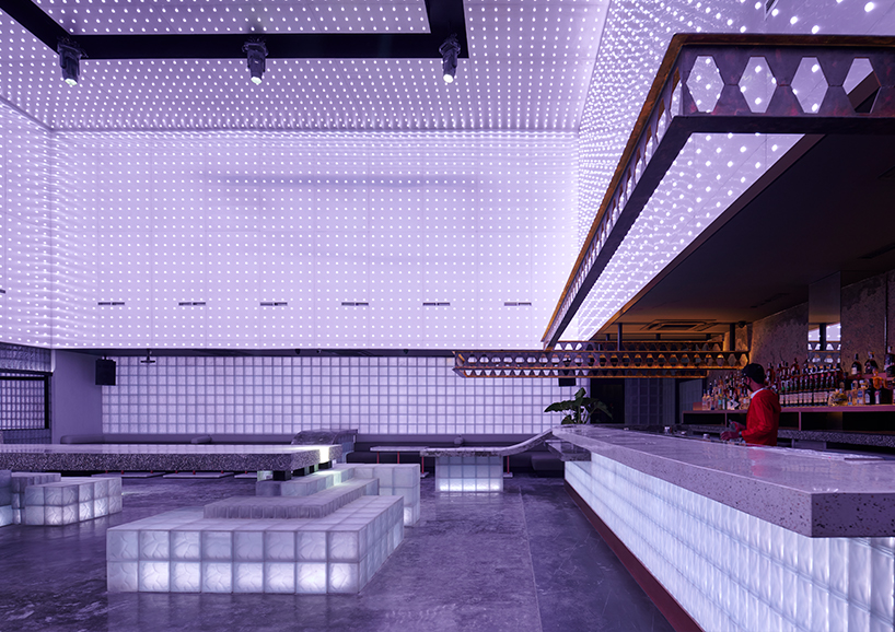 neon lights permeate glass block walls of renovated hidden basement bar in indonesia - 2