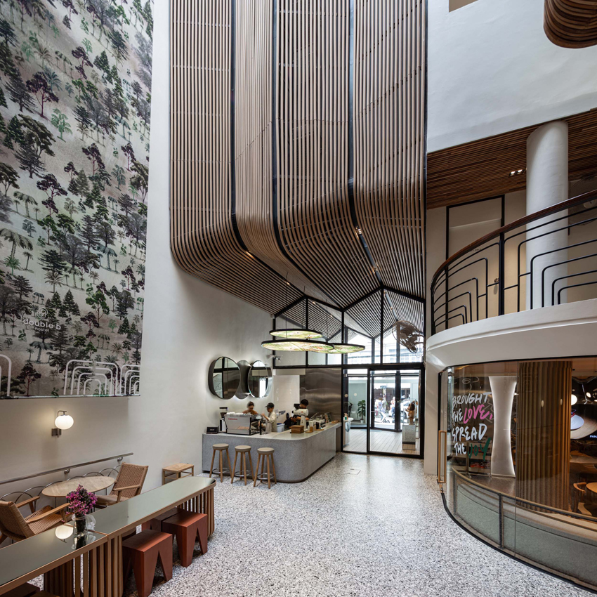 handcrafted wooden facade sweeps across VMA design studio’s hostel in bangkok