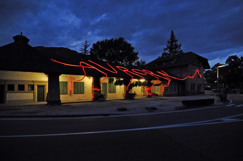 moradavaga's neon red light installation envelops former train station in italy