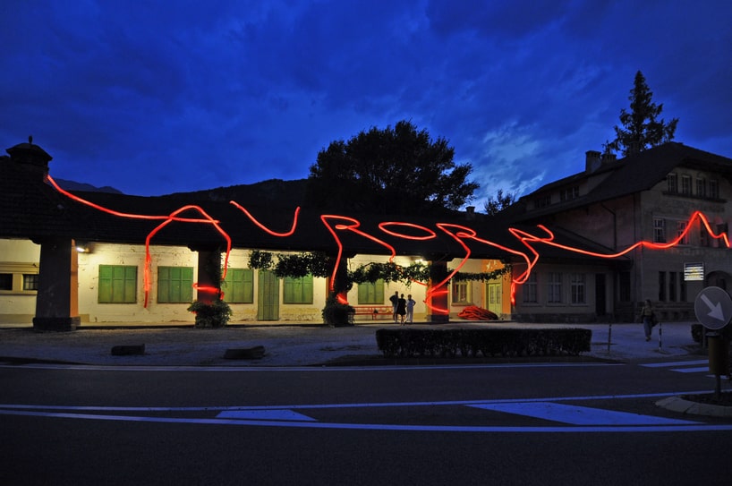 moradavaga's neon red light installation envelops former train station in italy