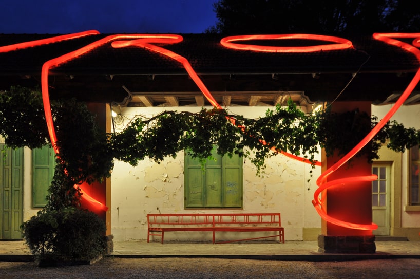 moradavaga's neon red light installation envelops former train station in italy
