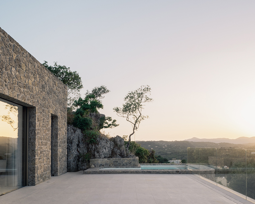 wrapped in stone, corfu house by georgios apostolopoulos overlooks the sea in greece