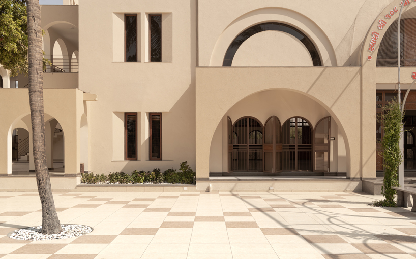arches carve into ivory-colored walls of raasa architects' ashram in indian village
