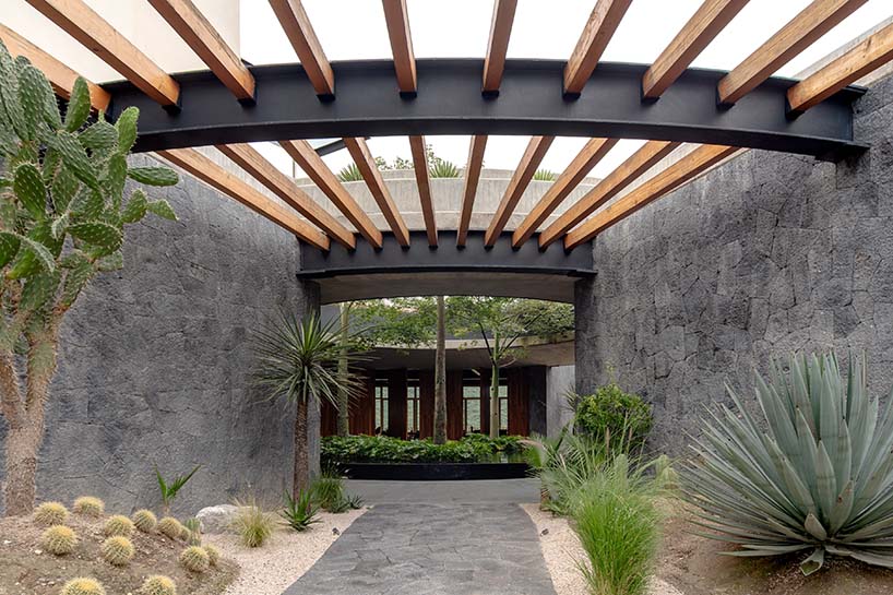 curved stone pavilion encloses circular reflecting pool for clubhouse in mexico