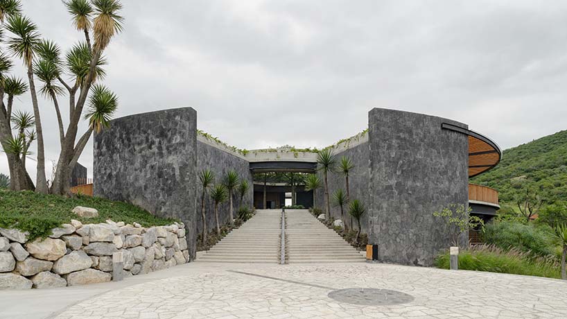 curved stone pavilion encloses circular reflecting pool for clubhouse in mexico