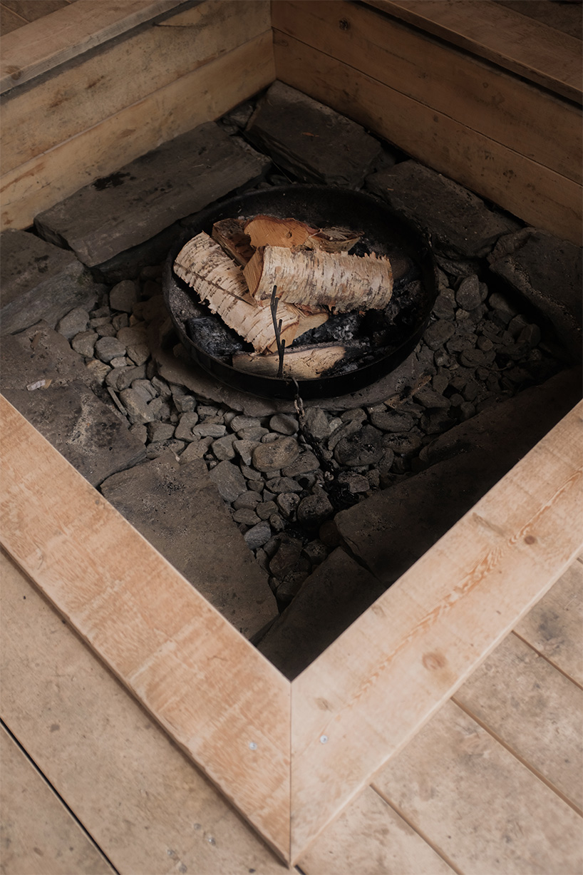 ma co builds glode fireplace shelter from reclaimed materials in northern norway 10